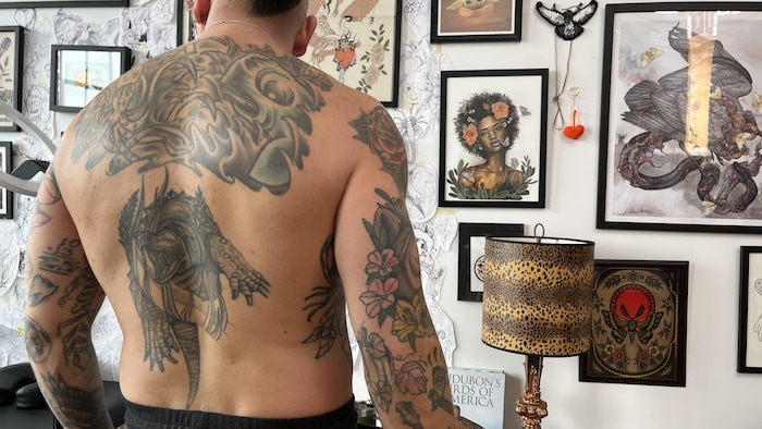 Un homme de dos avec ses tatouages.