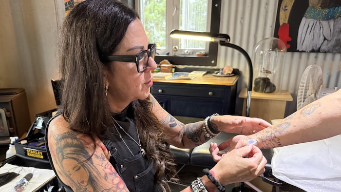 Line Bizier vérifie le placement d'un tatouage sur un poignet.