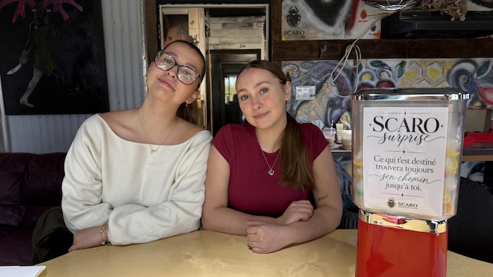 Raphaëlle et Victoria Hamel posent aux côtés une machine distributrice de gomme.
