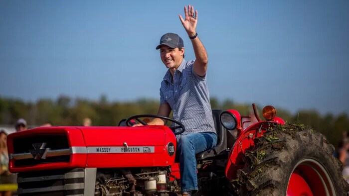 Justin Trudeau conduce un tractor en una feria rural.