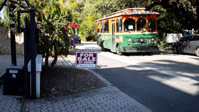 Un panneau « À vendre » se trouve devant une maison à Miami.