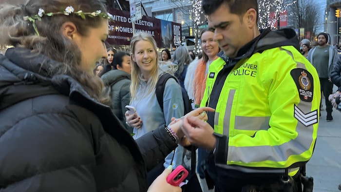 Un policier qui place un bracelet d'amitié au poignet d'une swiftie.