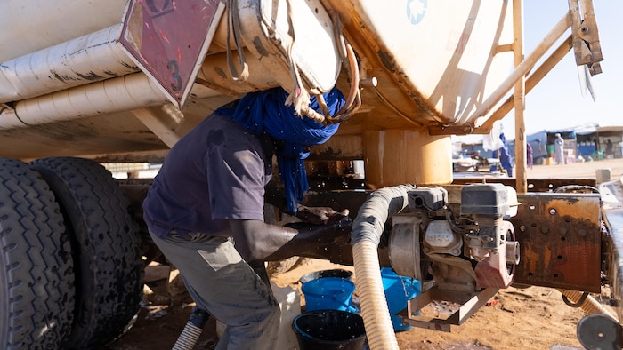 Un homme travaille près du camion-citerne.