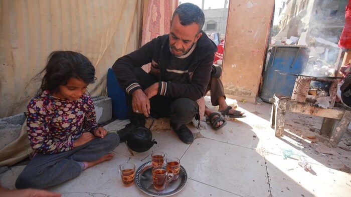 Emad Soliman Robaya Robaya prepares tea for one of his children in Rafah, Gaza Strip. (Mohamed El Saife/CBC)