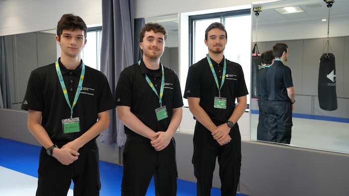 Trois jeunes hommes posent pour la photo.