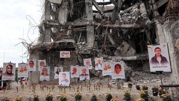 Des photos sont exposées au pied d'un immeuble démoli par un bombardement.