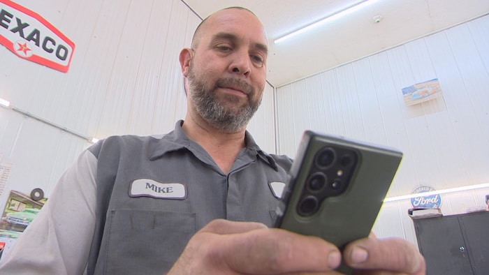 Mike Siwicki, regarde son téléphone.