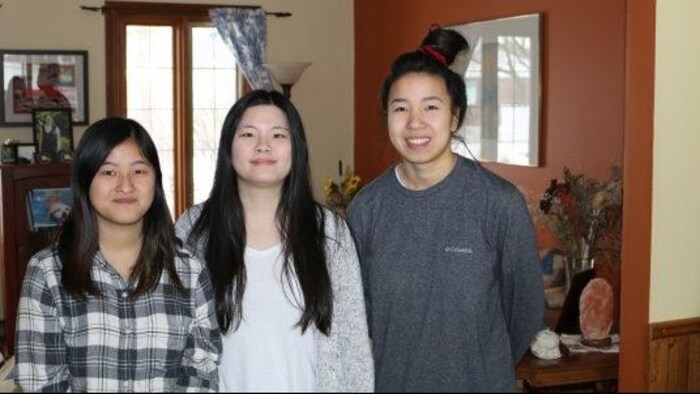 Les trois filles posent pour la photo dans une salle à manger.