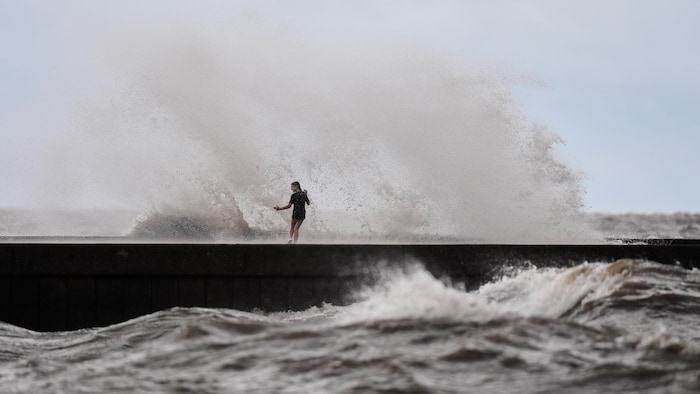 Des enfants jouent près des vagues qui se brisent sur la jetée de West End, au bord du lac Pontchartrain, alors que la tempête tropicale Bertha s'approche de la côte de la Louisiane, le mercredi 22 juillet 2026, à La Nouvelle-Orléans. 
