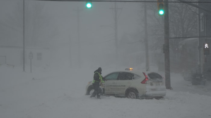 Un homme et une voiture dans la tempête.