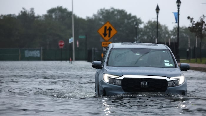 Une voiture sur une route inondée.