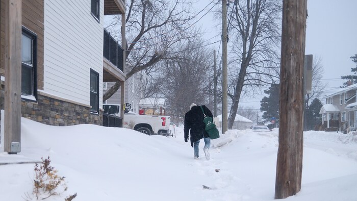 Une personne marche dans la neige.