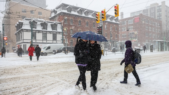Des personnes marchent dans la neige au centre-ville de Toronto.