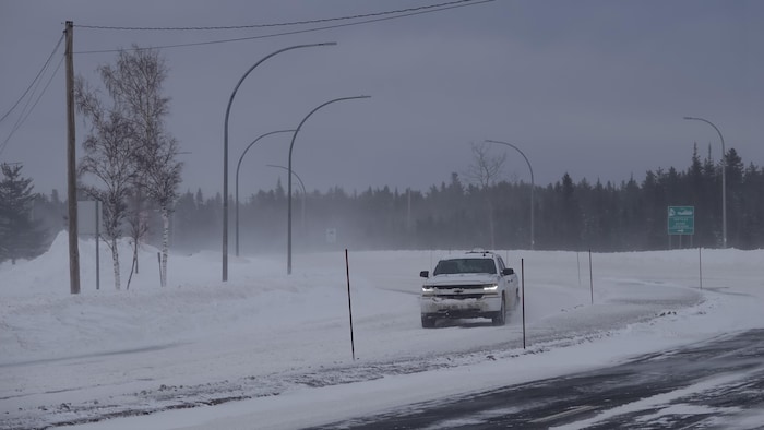 Un pick up sur un route enneigée.