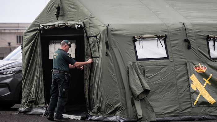 Un membre de la garde civile finit de monter une tente. 