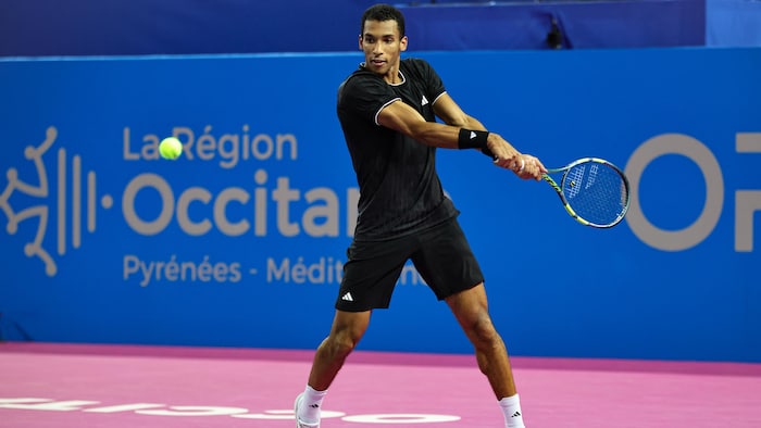 Un joueur de tennis s'apprête à frapper la balle.