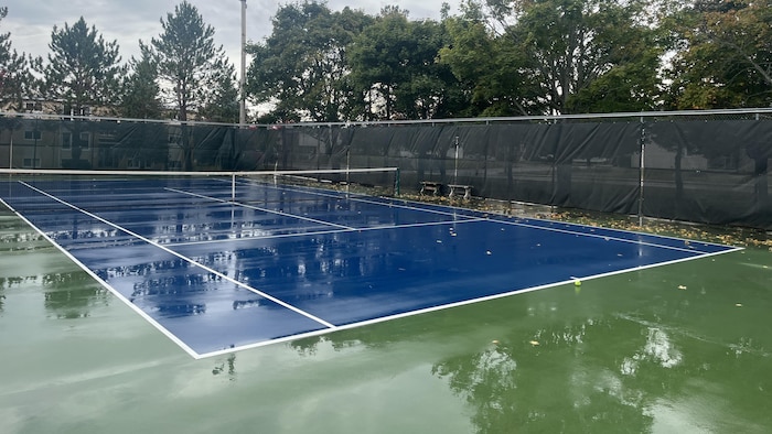 Un tribunal de tennis mouillé après la pluie.