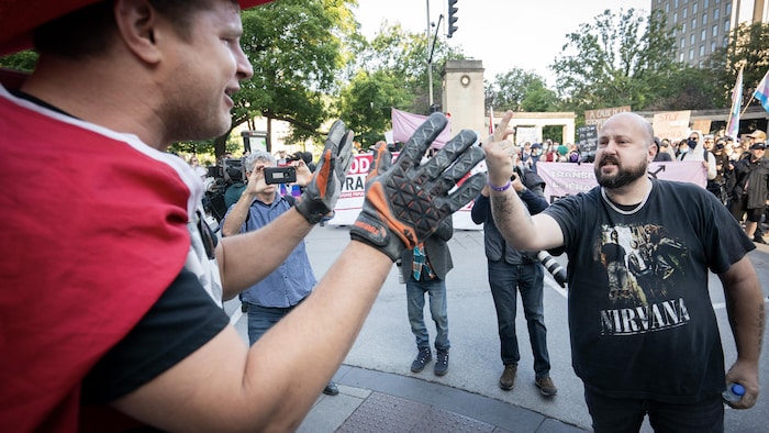Un membre du mouvement parental reçoit un doigt d'honneur d'un manifestant pour les droits LGBT.