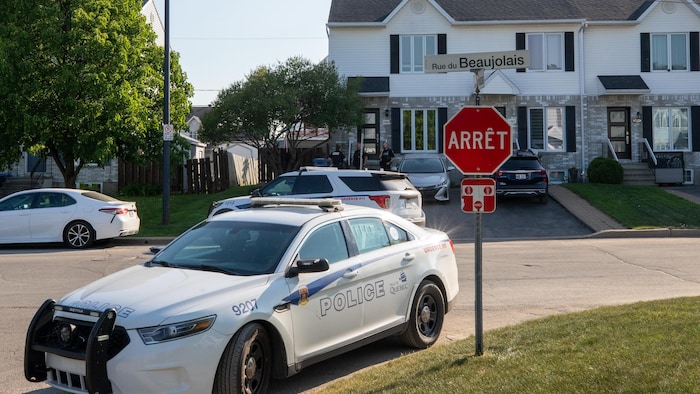 Des véhicules de police stationnés devant une résidence de Saint-Émile.
