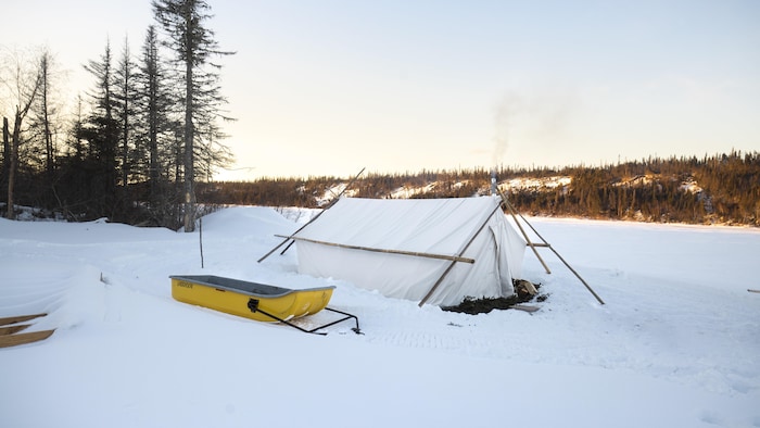 Une tente traditionnelle dans un paysage d'hiver.