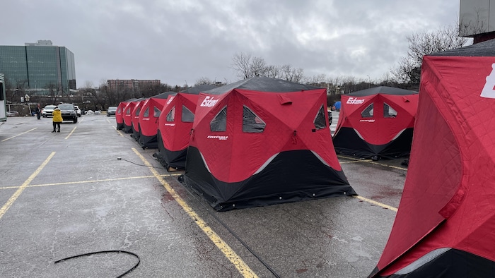 Des tentes rouges dans un stationnement. 
