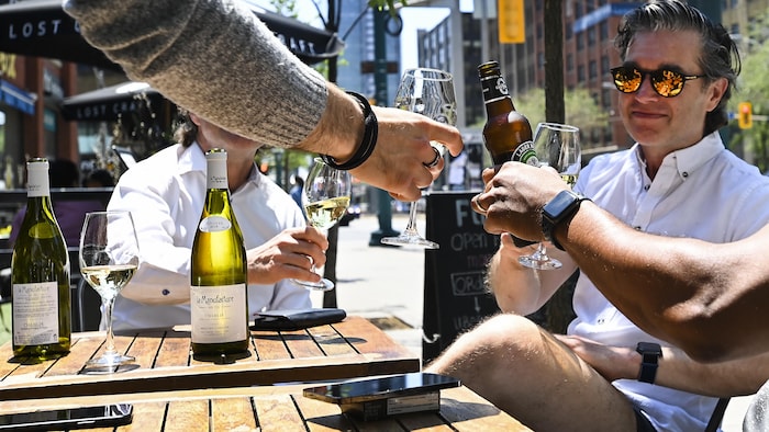 Des gens profitent de boissons et de moments conviviaux entre amis sur des terrasses extérieures du centre-ville de Toronto, le vendredi 11 juin 2021.