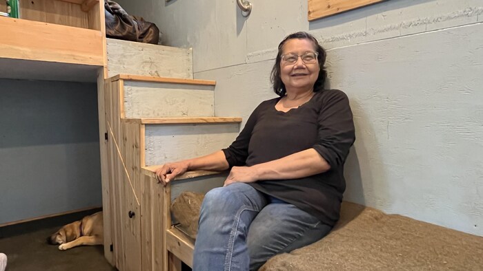 Une femme est assise dans sa mini-maison.