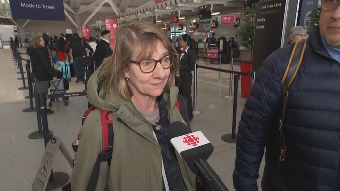 Une femme parle au micro d'une journaliste.