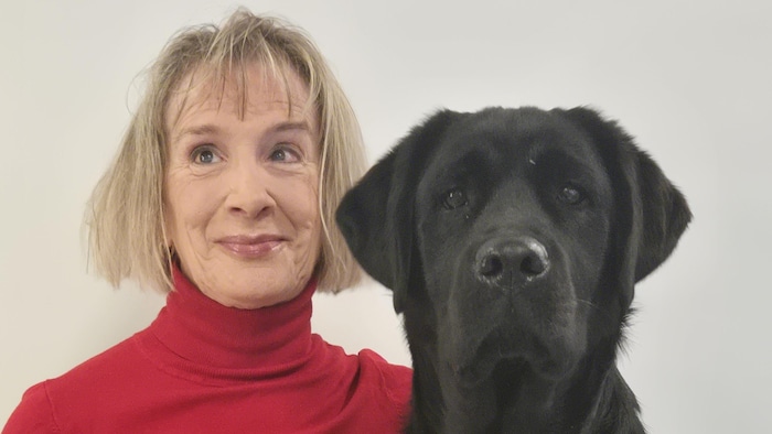 France Poulin pose le bras autour de son chien.