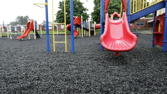 Un terrain de jeu d'enfants dont la surface est fait de pneus recyclés.