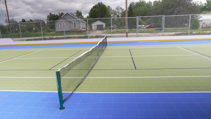Un terrain de tennis se transformant en terrain de squash.