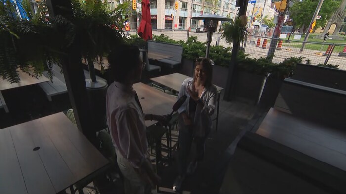 Alexandra Scott en entrevue sur la terrasse de l'établissement, entouré de grilles à cause des travaux sur l'intersection.