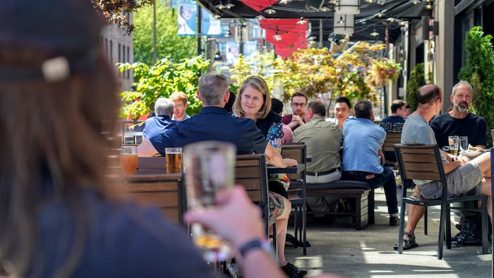 Des clients sont sur la terrasse d'un restaurant du quartier Yaletown de Vancouver le 14 juillet 2022.