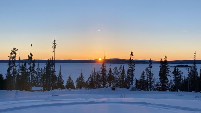 Un coucher de soleil au loin à travers des montagnes