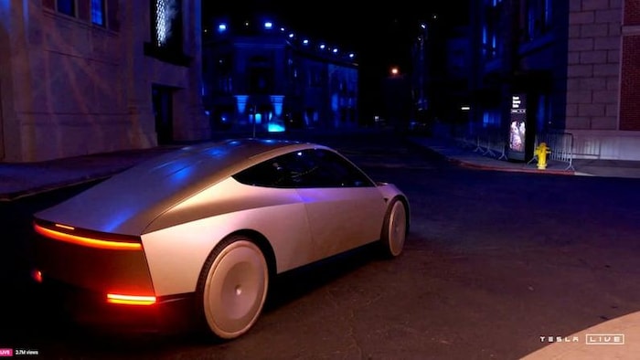 Une voiture aux allures futuristes dans une salle de montre d’un événement promotionnel.