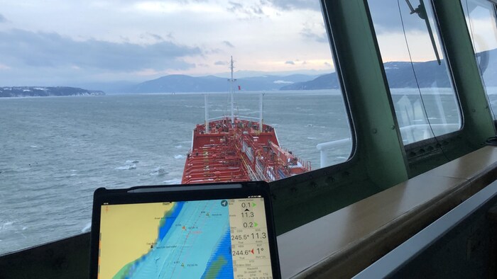 Un ordinateur portable installé dans un bateau sur lequel on peut voir une carte marine.