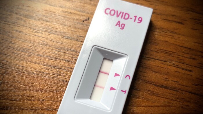 Un test antigénique rapide de dépistage de la COVID-19 affichant un résultat positif.