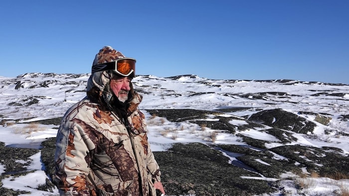 Gilles Monger, président du comité local de Tête-à-la-Baleine, au sommet d'une montagne. 