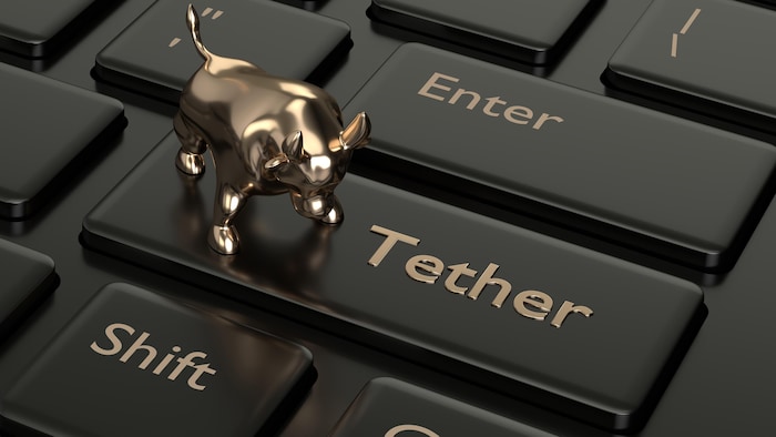 Illustration d'un taureau sur un clavier d'ordinateur, où il est indiqué "Tether" sur un bouton.