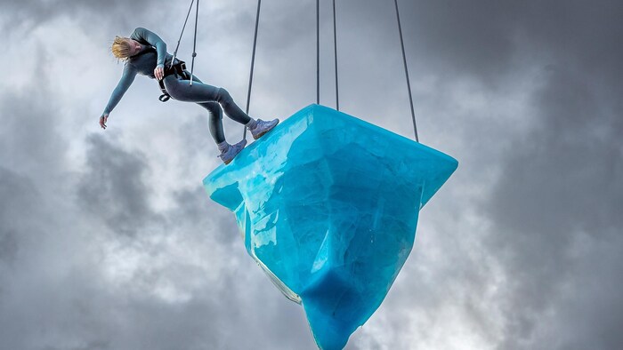Un danseur sur un bloc de glace suspendu.