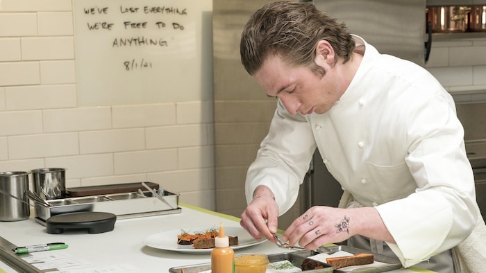Un cuisinier travaille au montage d'une assiette.