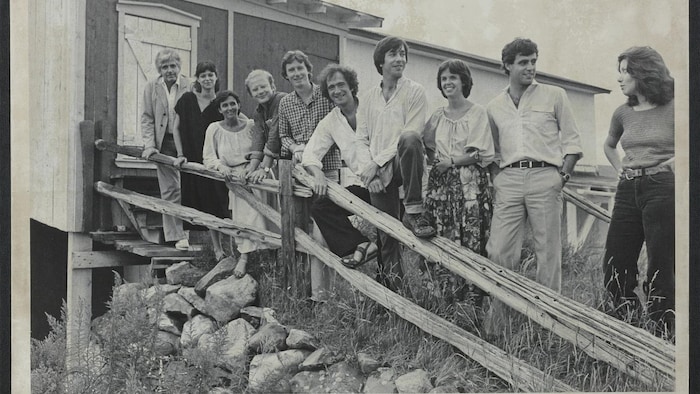 Des femmes et des hommes à l'entrée d'une grange.