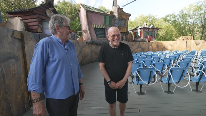Les deux fondateurs du Théâtre sont dans la salle. Derrière eux, le décor d'une pièce.