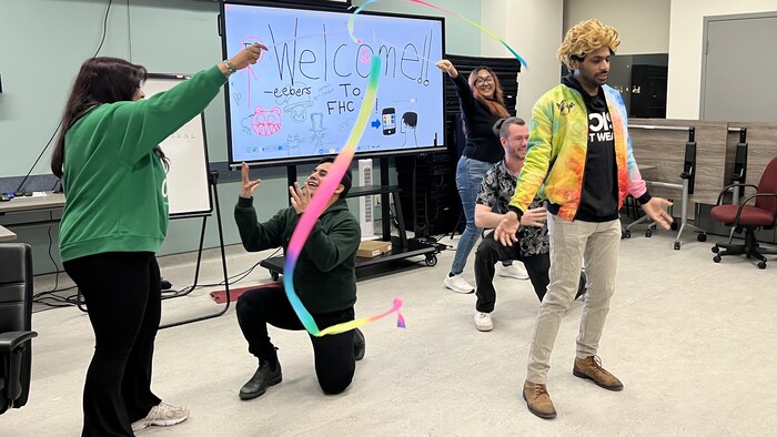 Cinq personnes chantent et brandissent des rubans de gymnastique.