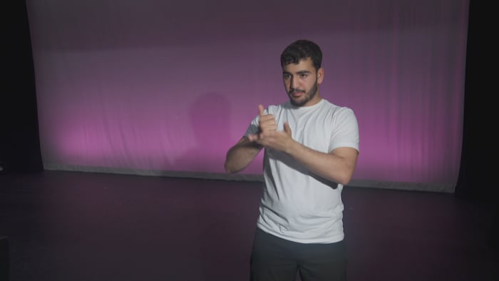 Abdullah Barhom parle en langue des signes devant la caméra.