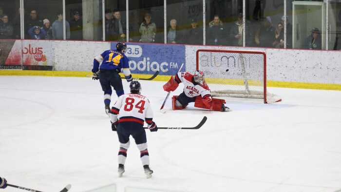 Un joueur de hockey déjoue un gardien.