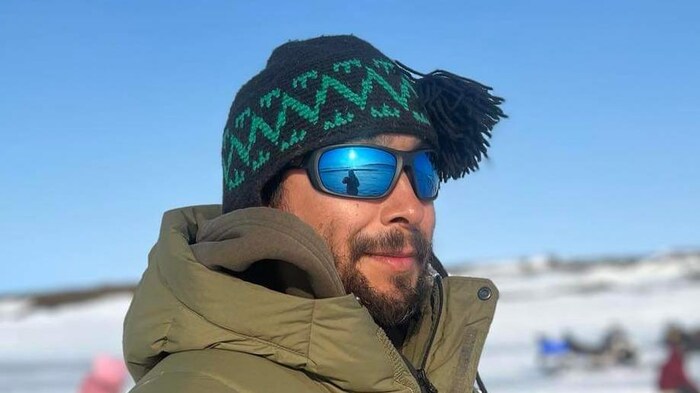 Thomassie Mangiok debout dans la neige.