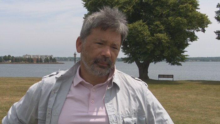 Tiago Hori dans un parc avec la ville de Charlottetown en arrière-plan.