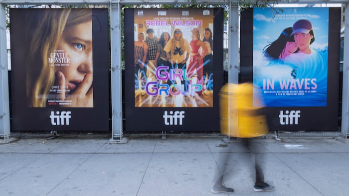 Une personne passe devant diverses affiches de films au Festival international du film de Toronto, lors de la journée d'ouverture, le jeudi 10 septembre 2026, à Toronto.