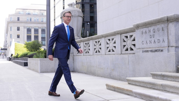 تيف ماكالِم حاكم مصرف كندا المركزي  يسير أمام مقرّ المصرف.